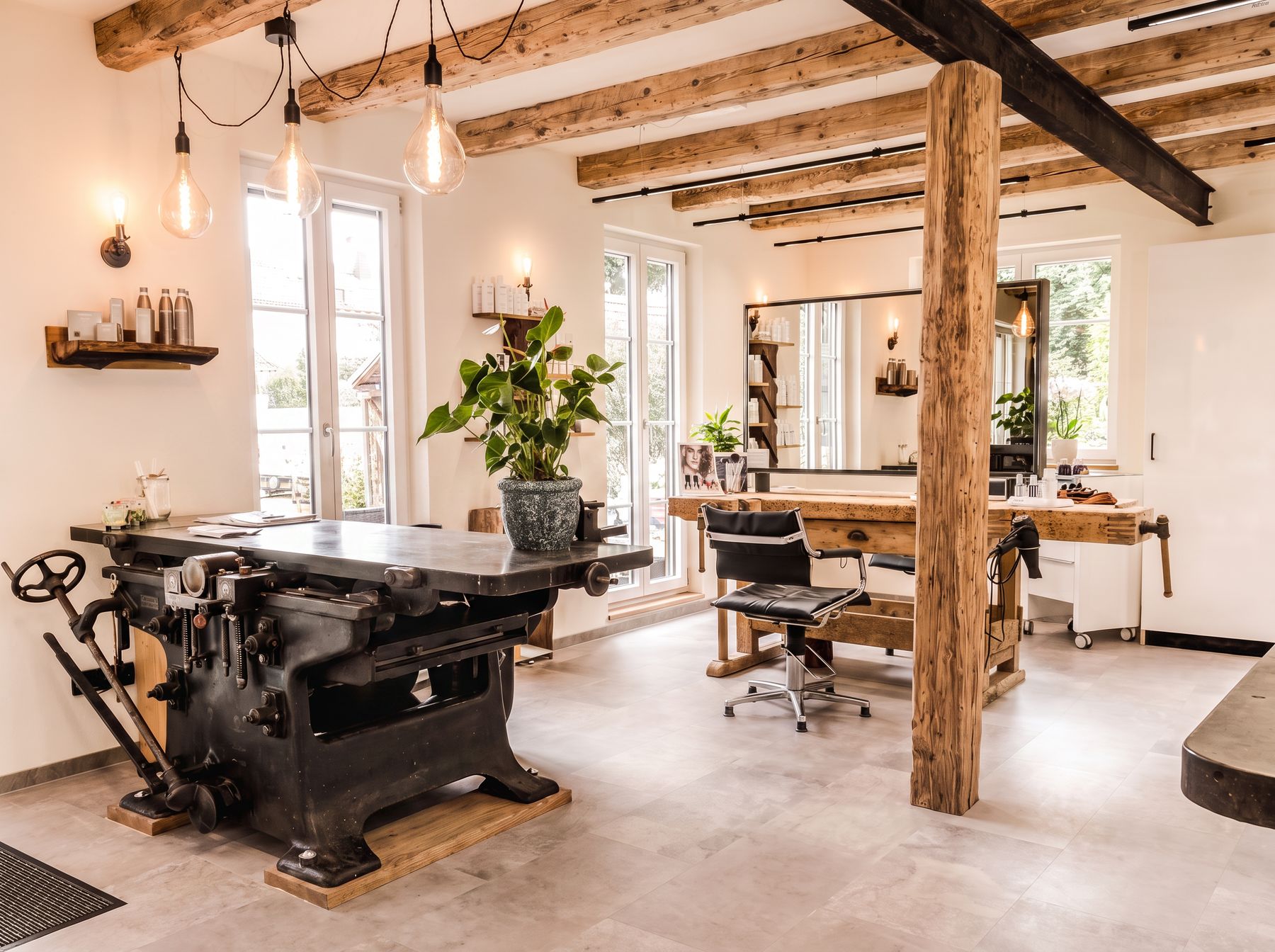 Salon mit Altholzbalken und Werkstattmotiven
